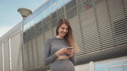 Woman Using Smartphone by Modern Building