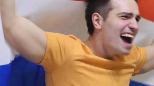 Young Adult Shouting and Celebrating with Flag