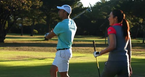 Golfing Couple Celebrates with High-Five on Course