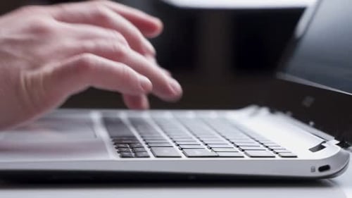 Nahaufnahme von Männerhänden, die am Schreibtisch auf der Laptoptastatur tippen. Nicht wiederzuerkennender Mann schreibt E-Mail
