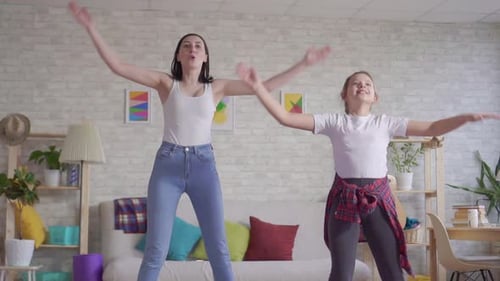 Woman and Girl Exercise Together at Home