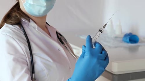 Krankenschwester hält eine Spritze mit Medizin in der Hand Sie ist bereit, eine Injektion zu geben