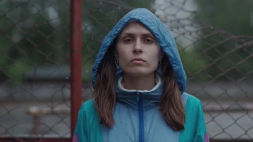 Woman in Hooded Jacket Stands in the Rain