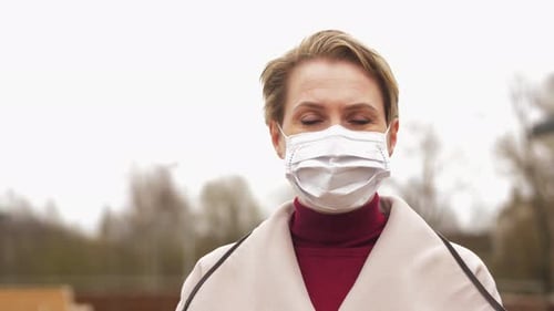 Woman Wearing a Surgical Mask in an Urban Setting