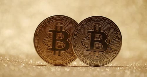 Two Bitcoin Coins Glowing on Shiny Background