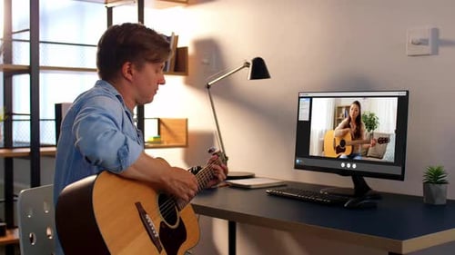 Man Taking Guitar Lesson Online with Instructor