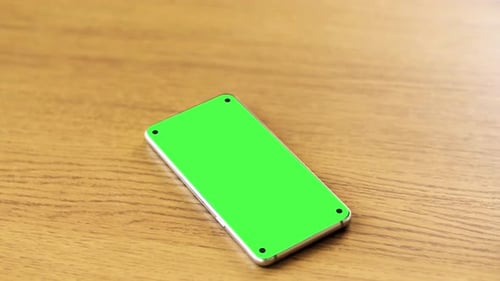Smartphone with Blank Green Screen on Wooden Table