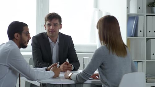 Geschäftsleute sprechen mit einer Kollegin im Büro