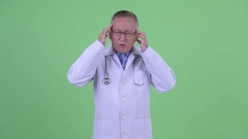 Doctor Rubbing Temples in Discomfort on Green Screen