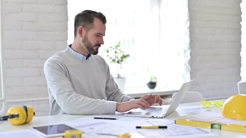 Man Working on Laptop at Desk