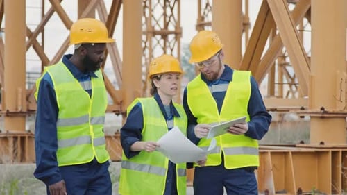 Multi-Ethnic Construction Workers Discussing Blueprint