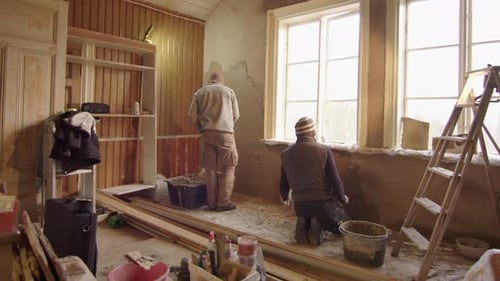 Men Restore Walls in a Brightly Lit Room