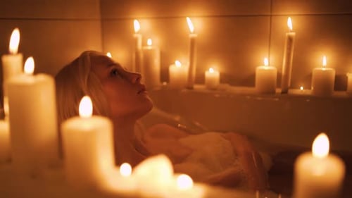 Woman Relaxing in Bubble Bath with Candles