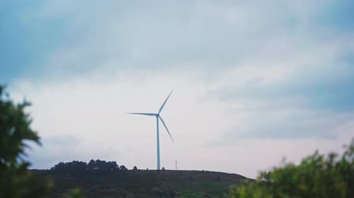 Wind Turbine Spinning on Rural Hilltop on Cloudy Day