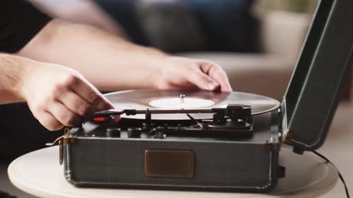 Hands Adjusting Needle on Vintage Record Player