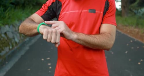 Man Checks Fitness Tracker During Run