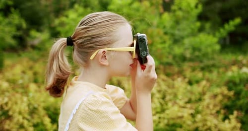 Girl Taking Pictures with Colorful Camera in Nature
