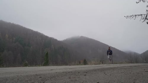 Athletic Man Runs on Rural Mountain Road