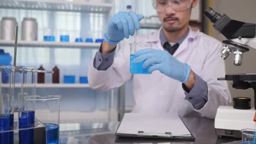 Lab scientist pouring liquid in lab flask. Close up of female scientist doing laboratory experiment