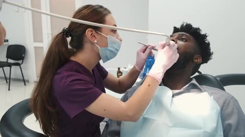 Dentist Examining a Patient's Teeth in the Dentist Office