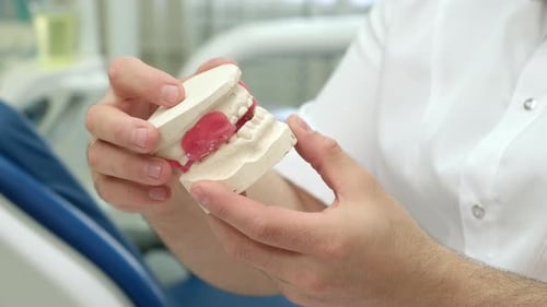 Dentist Adjusting Dental Mold in Office Setting