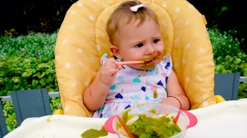 Bebê está comendo purê de brócolis
