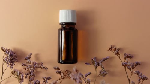 Herbal essential oil glass bottle mockup beige flowers background Spa aromatherapy beauty cosmetics