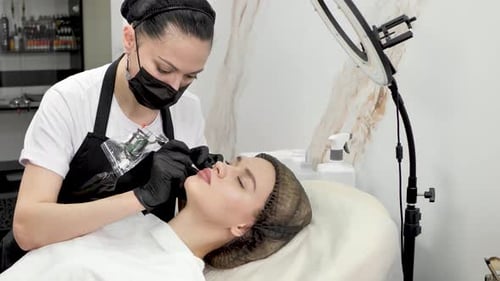 Eine Kosmetikerin schminkt die Lippen in einem Schönheitssalon permanent