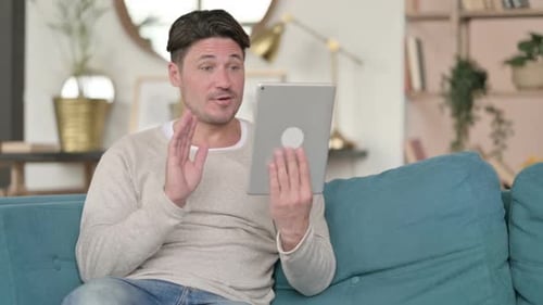 Man Video Chats on Tablet at Home