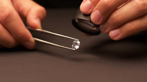 Faceted Gemstone Examined with Magnifying Glass