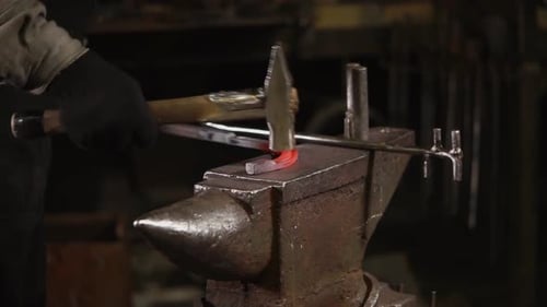 Blacksmith Shaping Red Hot Metal on Anvil
