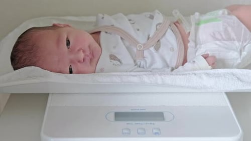 Infant Lying on Scale Weighing