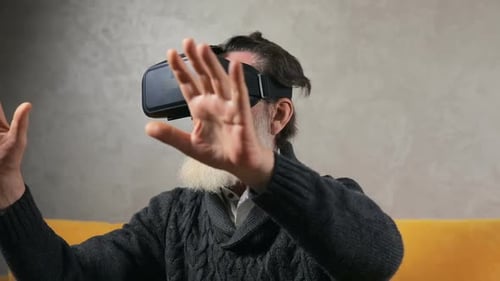 Senior Man Uses Virtual Reality Headset Indoors