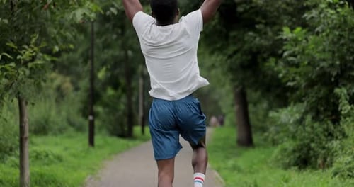 Jogger Raising Hands in Park Slow Motion Shot