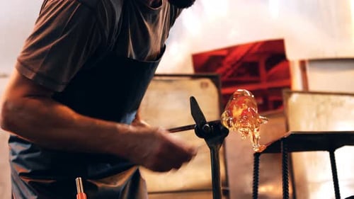Glass Blower Shaping Molten Sculpture with Tools