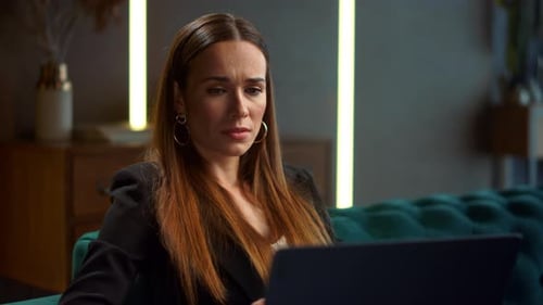 Woman Works on Laptop With Concerned Expression