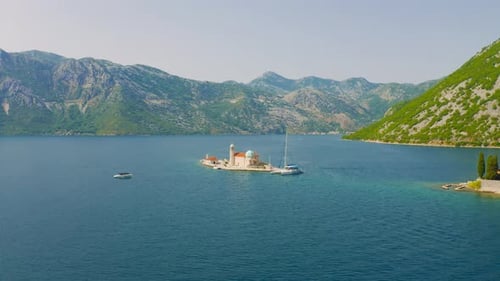 Drohnenansicht einer Kirche Unserer Lieben Frau von den Felsen in Perast Montenegro