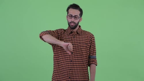 Angry Young Bearded Persian Hipster Man Giving Thumbs Down