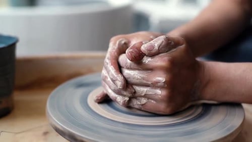 Hands Working Clay on Pottery Wheel in Studio