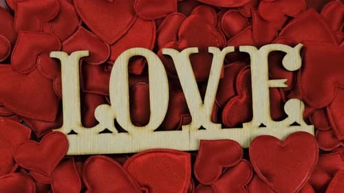Wooden Love Text on Red Hearts Background