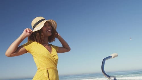 Afroamerikaner trägt Hut und Fahrrad am Meer