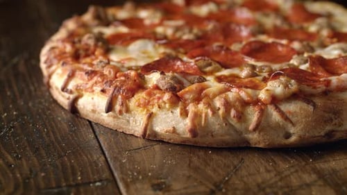 Cutting a Savory Pizza on Wooden Table