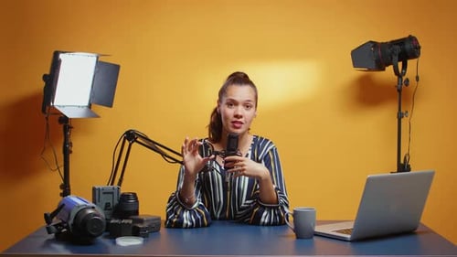 Female Content Creator Discussing Camera Lens in Studio