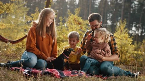 Happy Family with Children and a Dog in an Autumn Park