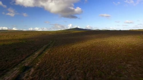 Aerial view of a dirt road winding through mountainous terrain
