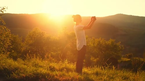 Woman Captures Sunset Vista on Mobile Phone