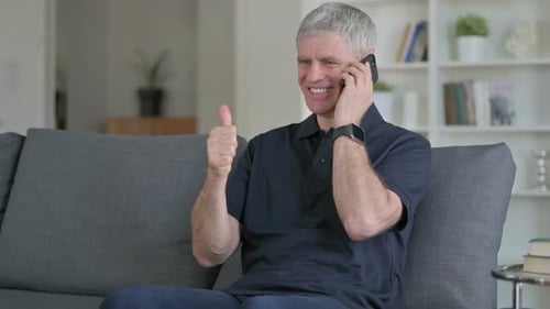 Man Sitting On Couch Talking on Phone