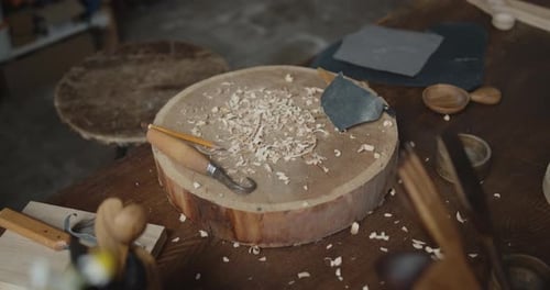 Lieu de travail du menuisier : établi, outils de sculpture, papier abrasif et copeaux de bois