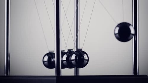 The balls of a Newtons Cradle colliding in slow motion
