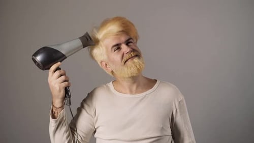 Man With Blond Hair Blow Drying His Hair